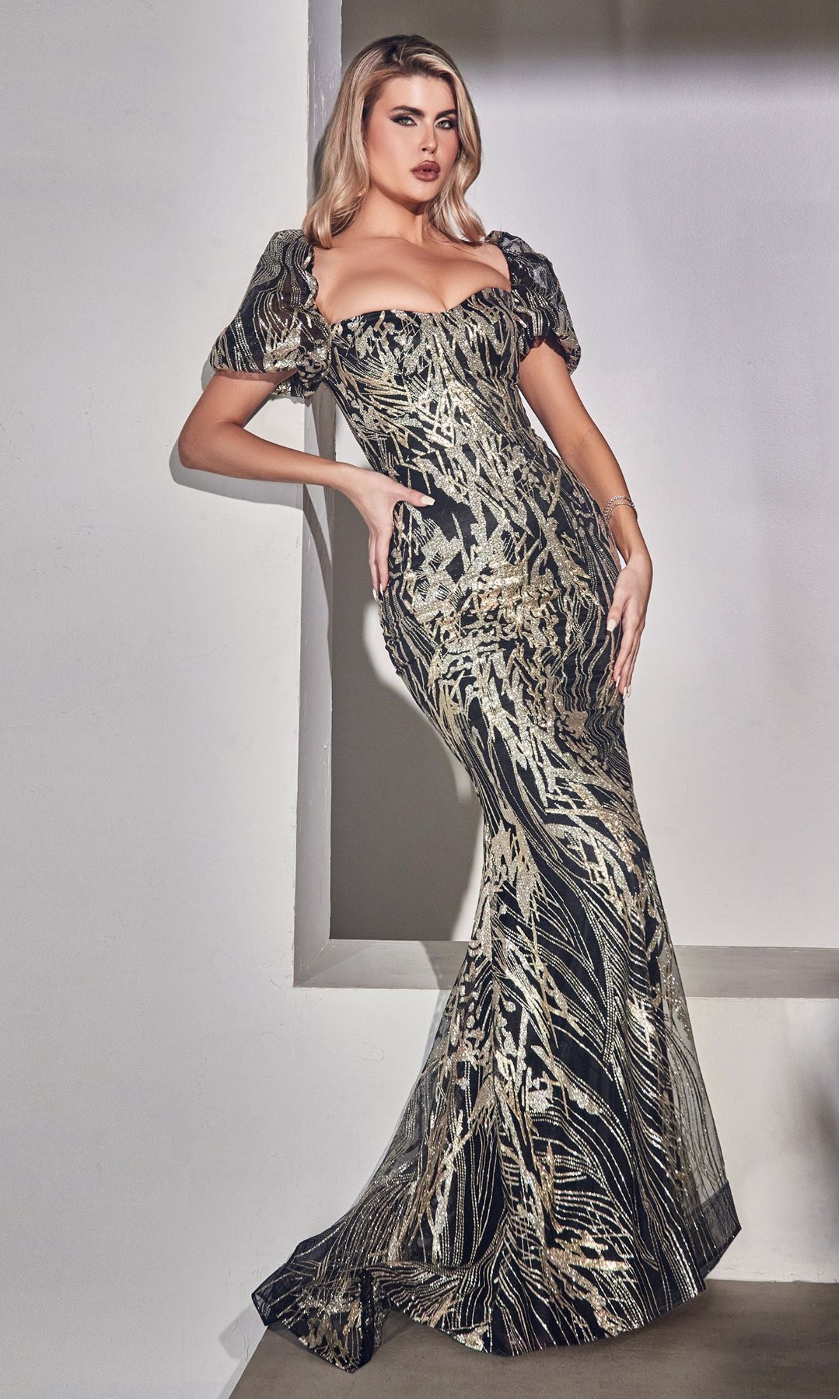 A woman in the Glitter-Print Puff-Sleeve Long Prom Dress J833, featuring black and gold glitter and a striking mermaid silhouette.